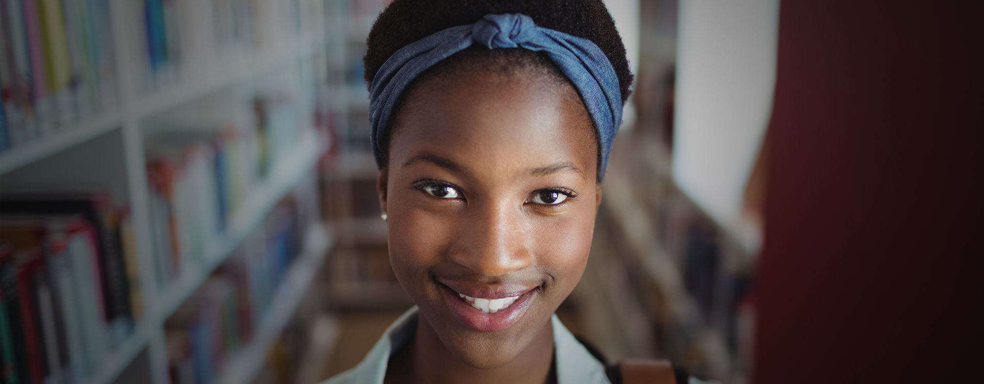 portrait-of-schoolgirl-smiling-in-library_vignette